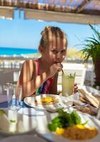 Nice kid girl drinking refreshing beverage photo