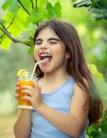 alegre niña Bebiendo jugo foto