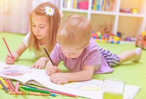 Happy baby boy  girl enjoying homework photo