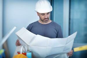 Architect builder studying layout plan of the rooms photo