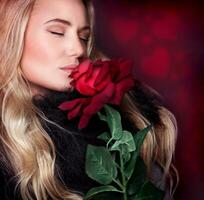Beautiful woman smelling rose photo