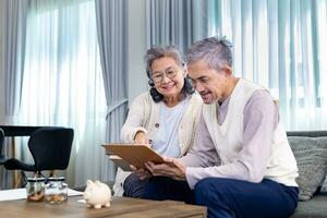 Senior Asian couple is planning on retirement saving fund looking at their income and expense and annual pension after taxes for elder long term financial investment and budget photo