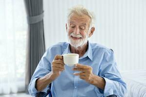 Senior caucasian man is drinking and enjoying his hot herbal tea in morning for healthy, longevity and retirement happiness photo