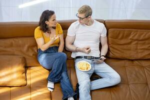 Caucasian couple is spending time together watching movie in living room at home for weekend and holiday activities in leisure and happiness photo