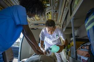 Team of paramedic is helping the senior patient who is stop breathing from car crash by using respirator for heart attack and street accident photo