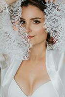 the bride in an open robe, open bust. Great hairstyle. lace robe, close-up portrait, looking into the camera photo