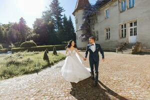 the bride and groom run against the background of the castle in spring flowers and beautiful light. An incredible couple photo