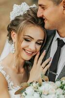 bride and groom on the background of a fairy-tale forest. Royal wedding concept. the groom embraces the bride. Tenderness and calmness. Bride's smile photo