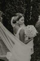 Wedding bouquet of beautiful white wedding flowers in the hands of the bride. outdoor photo in the park. Stylish bride. Delicate make-up