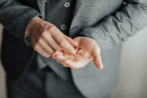 foto de Boda anillos ese mentira hermosamente en el del novio manos. un hermosa foto con detalles de el boda. Boda día. luz. un elegante hombre. hermosa manos