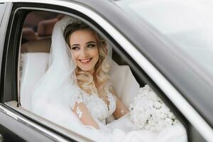 white-haired bride jewelry head sitting in a black car on your wedding day with a bouquet. Portrait of the bride. lush white lace dress photo