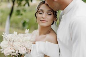 hermosa Boda Pareja. el novio Besos el novia en el frente. contento Boda fotografía de novia y novio a Boda ceremonia. foto