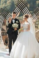 Wedding ceremony painting in nature. Brides and grooms stand by the golden arch during the painting ceremony and show off their engagement rings. An arch in the form of a tulip and fresh flowers photo