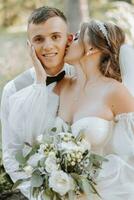 retrato de un hermosa Pareja en amor en tu Boda día. un caminar en el parque en el luz de sol. increíble Besos y abrazos de el novia y novio con un ramo de flores foto