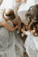 novias ayuda el novia poner en su Boda zapatos. hermosa hembra piernas de cerca foto