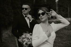 hermosa Boda Pareja. elegante novia en negro lentes en el primer plano. contento Boda foto de el novia y novio.