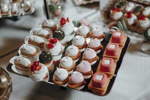 Candy bar. Table with sweets, candies, dessert. cakes and berries in the candy bar. Candy bar with delicious mini cakes, selective focus photo