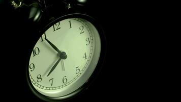 il allarme orologio su un' nero sfondo, nel il stile di lasso di tempo video. video