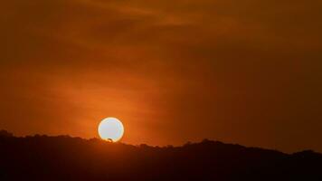 Time lapse of the sun rising over hills that are covered with clouds, in the style of smokey background. video