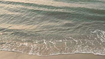 onda spruzzi nel Alba o tramonto su un' tropicale spiaggia. video