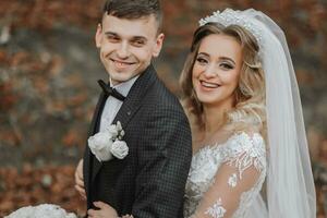 retrato de un joven Pareja de el novia y novio en su Boda día en naturaleza. el novia abrazos el novio desde detrás. elegante retrato. sitio para derechos de autor foto