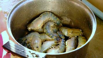 A woman's hand is arranging river prawns that have had their tentacles and limbs cut off. video