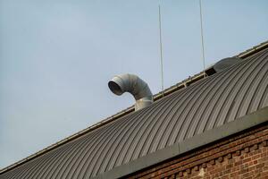 old roof with part of metal chimney photo