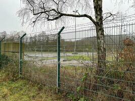 fenced off industrial area in the rain and fog photo