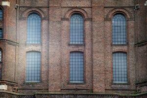 antiguo ventana en un ladrillo pared de un industrial por poco 100 años antiguo edificio foto