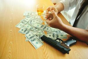 Businessman with money, alcohol and gun, financial problems, Stressful gambling addicts are experiencing financial problems and bankruptcy. photo