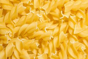 Uncooked Fusilli Pasta. A Culinary Canvas of Spiral Macaroni, Creating a Lively and Textured Background for Gourmet Cooking. Dry Pasta. Raw Macaroni - Top View, Flat Lay photo