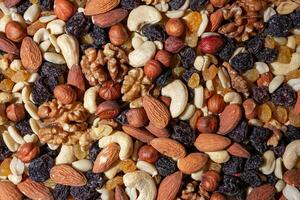 Mixed Nuts. Almonds, Walnuts, Cashews, Peanuts, Hazelnuts, Dried Prunes and Raisins. Different Nut Mix. Background from Various Nuts and Dried Fruits photo