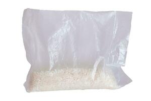 un el plastico bolso de blanco largo grano arroz - aislado en blanco antecedentes. pequeño transparente paquete con seco arroz - aislamiento foto