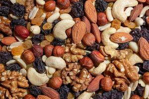 Mixed Nuts. Almonds, Walnuts, Cashews, Peanuts, Hazelnuts, Dried Prunes and Raisins. Different Nut Mix. Background from Various Nuts and Dried Fruits photo