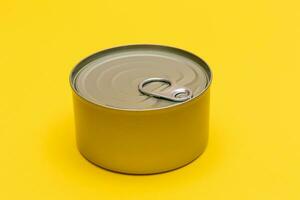 Unopened Tin Can with Blank Edge on Yellow Background. Canned Food. Aluminum Can for Safe and Long Term Storage of Food. Steel Sealed Food Storage Container photo