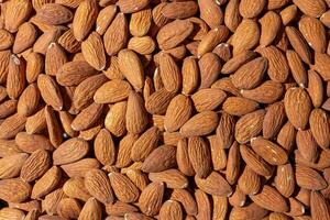 Scattered Almonds. Background from Almond Nuts. Natural High-Calorie Snacks photo