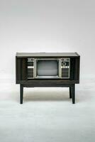 Retro old television with clipping path isolated on white background. TV stand and blank screen, with vintage radio and telephone, technology. photo