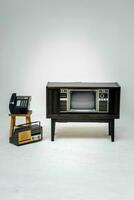 Retro old television with clipping path isolated on white background. TV stand and blank screen, with vintage radio and telephone, technology. photo