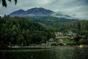 Natural panoramic portrait. Sarangan Lake with fog and boats in the morning. photo