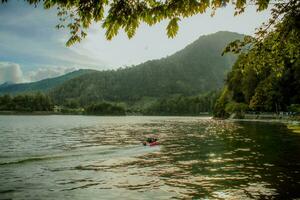 Natural panoramic portrait. Sarangan Lake with fog and boats in the morning. photo