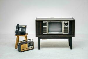 Retro old television with clipping path isolated on white background. TV stand and blank screen, with vintage radio and telephone, technology. photo