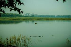 Portrait of fishermen preparing to fish in a reservoir or lake with a canoe or wooden boat. photo