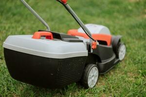 Lawn mover on green grass in modern garden. Machine for cutting lawns. Safety equipment with garden tools photo