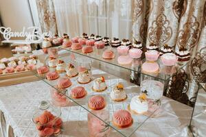 A delicious wedding. Candy bar for a banquet. Celebration concept. Fashionable desserts. Table with sweets, candies. candy bar in pink style photo