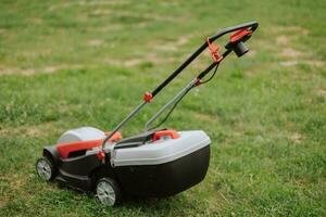 Lawn mover on green grass in modern garden. Machine for cutting lawns. Safety equipment with garden tools photo