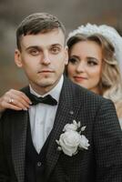 portrait of a young couple of the bride and groom on their wedding day. the bride hugs the groom from behind. stylish portrait close-up photo