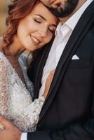 Wedding portrait. A red-haired bride in a white dress, leaning against her groom. Beautiful curls. Sincere smile. Elegant dress. Bearded man photo