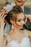 bride and groom on the background of a fairy-tale forest. Royal wedding concept. The groom puts on the bride's tiara. Tenderness and calmness. Portrait photography photo