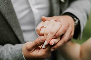 Close up shot of a bride and grooms hands interlocked showing a diamond ring, close up of couple holding hands on their wedding day walking together down the aisle photo