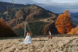 A couple in love in the mountains. Wedding in the mountains. Newlyweds have fun against the background of mountains and enjoy the view. photo